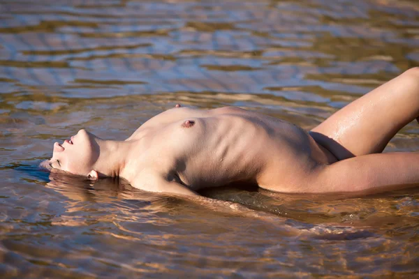 stock image Nude woman lying in water