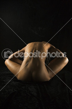 Nude woman sitting.