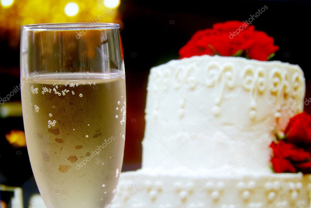 Glass of champagne and wedding cake with flowers